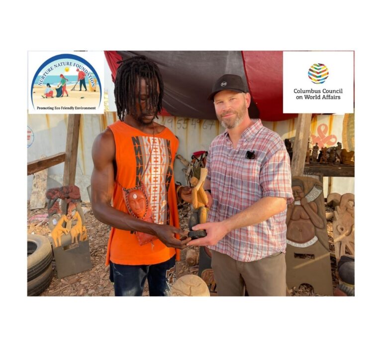 (Left) Maxwell Adjei, NNF carving instructor and sculptor, presenting a carved artifact from driftwood collections to the president of the Columbus Council on World Affairs, Patrick Terrien.